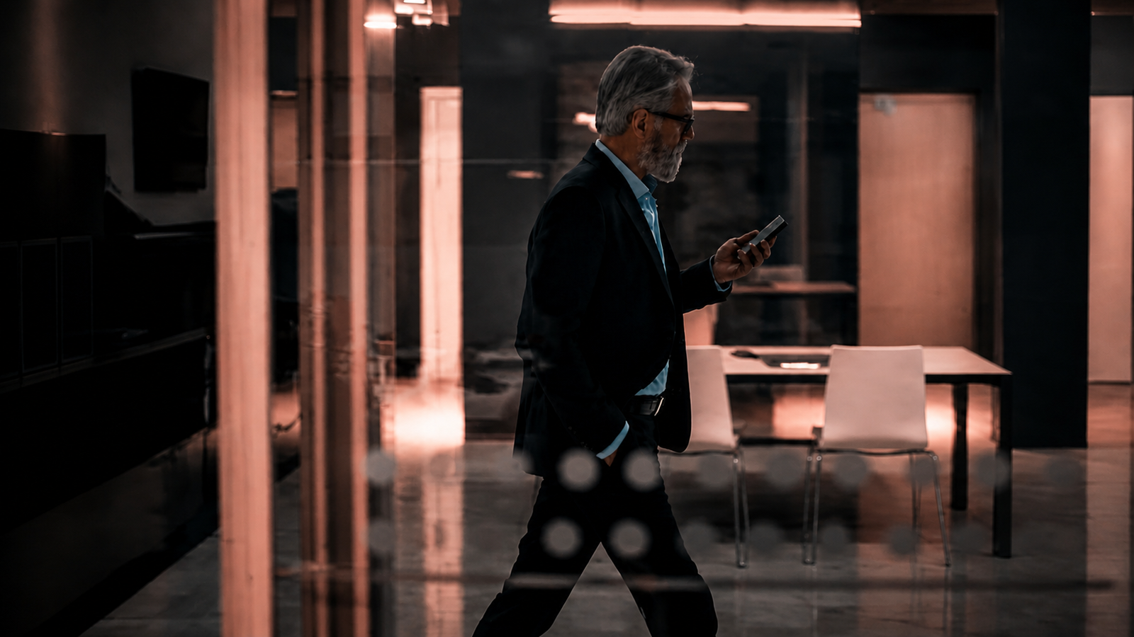 Executivo atravessa um ambiente corporativo marcado por vidro, luz e linhas precisas.